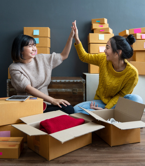 two young female entrepreneurs high fiving